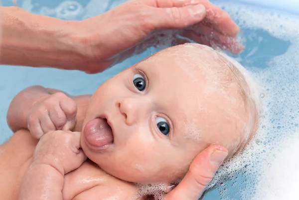 Menino recém-nascido no banho apaga a língua — Fotografia de Stock