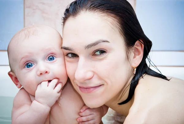 Moeder en baby in een badkamer — Stockfoto