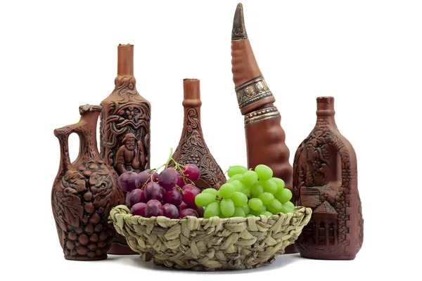 Frascos de vino-botellas de arcilla con vino y uvas en frente —  Fotos de Stock
