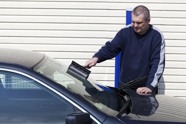 Мужчина моет окна машины — стоковое фото