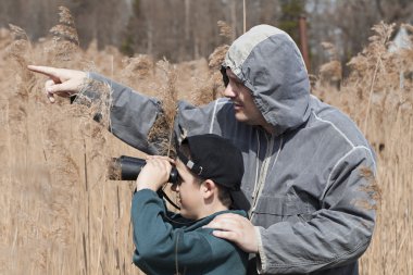 Father and son watching the birds at the lake clipart