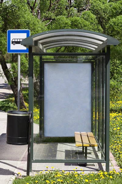 Bus stop with the ad behind the glass — Stock Photo, Image