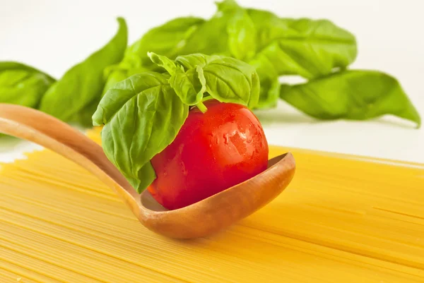 Tomaten und frisches Basilikum auf dem Löffel — Stockfoto