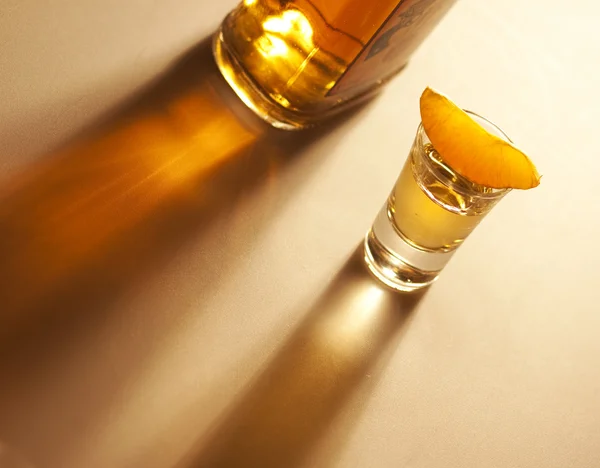Tequila tiro com laranja e garrafa — Fotografia de Stock