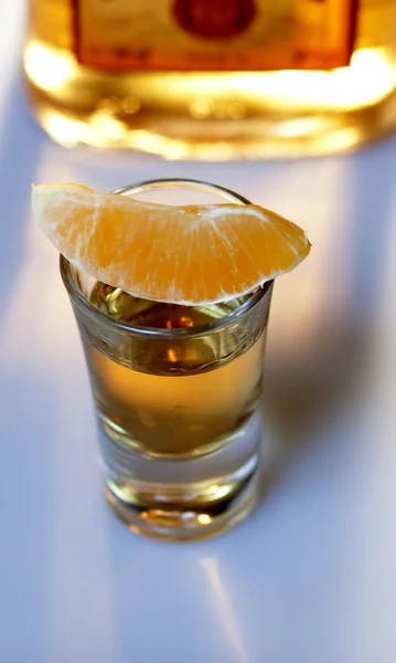 Tequila shot met sinaasappel en fles — Stockfoto