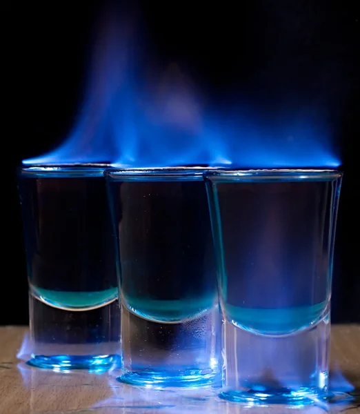 Burning drink in shot glass on a table — Stock Photo, Image