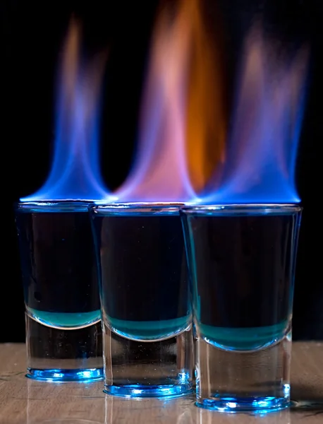 Bebida quemada en un vaso de chupito sobre una mesa —  Fotos de Stock