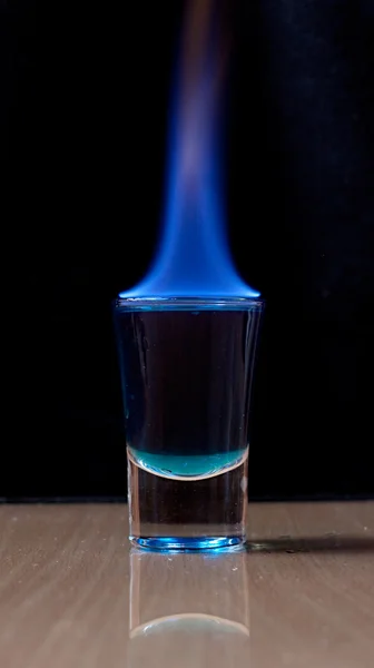 Bebida quemada en un vaso de chupito sobre una mesa — Foto de Stock