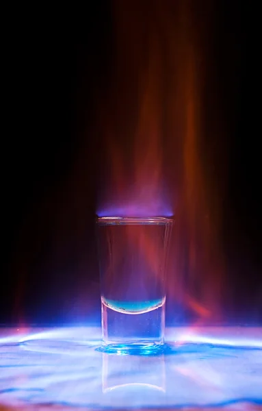 Bebida quemada en un vaso de chupito sobre una mesa — Foto de Stock