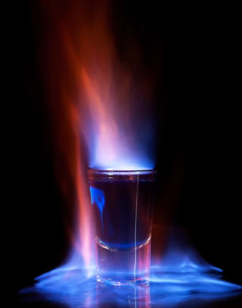 Brennendes Getränk im Schnapsglas auf einem Tisch — Stockfoto