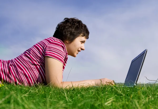 Mladá neformální žena pracující na notebooku venku — Stock fotografie
