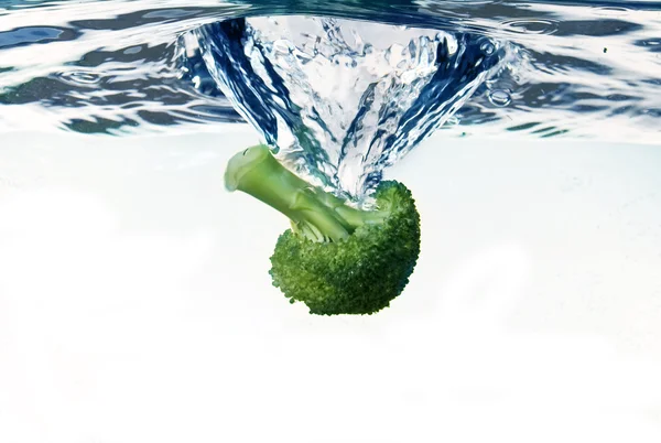 Broccoli falling into water — Stock Photo, Image