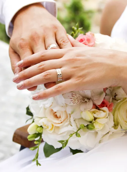 Руки и кольца на свадебный букет — стоковое фото