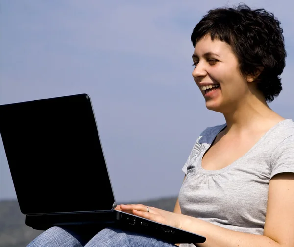 Jovem mulher casual trabalhando no laptop ao ar livre — Fotografia de Stock