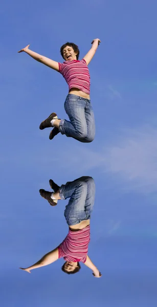Прыгающая женщина в солнечный день на фоне голубого неба — стоковое фото