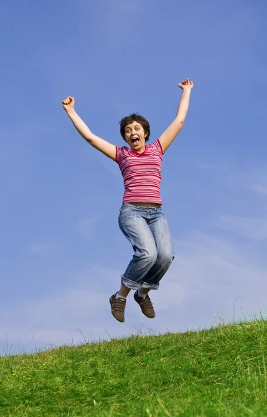 Hoppa kvinna på en solig dag mot en blå himmel — Stockfoto