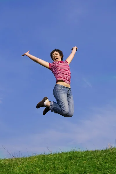 Vrouw springen op een zonnige dag tegen een blauwe hemel — Stockfoto