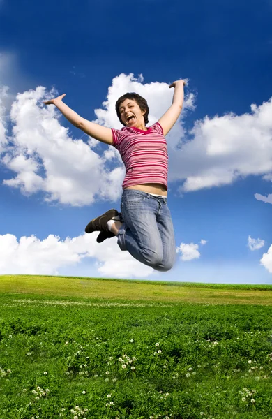 Saltando mulher em um dia ensolarado contra um céu azul — Fotografia de Stock