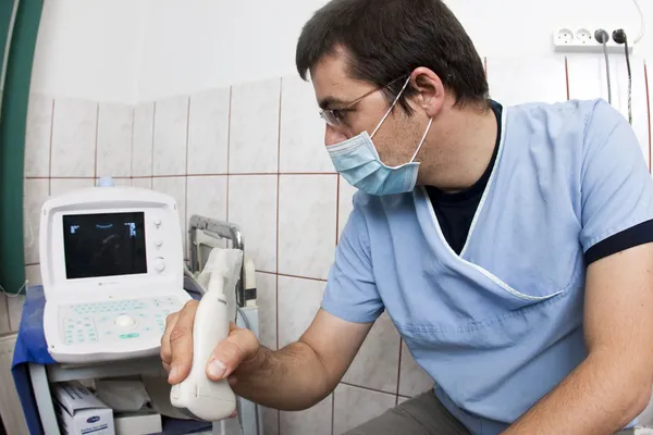 Médico mirando el dispositivo de ultrasonido moderno —  Fotos de Stock