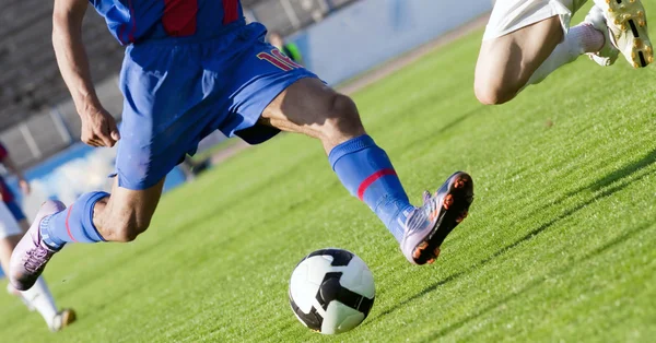 Футболист бежит за мячом — стоковое фото