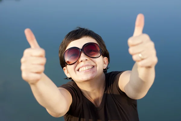 Young brunette girl with big funny sunglasses making thumbs up gesture — Stock Photo, Image