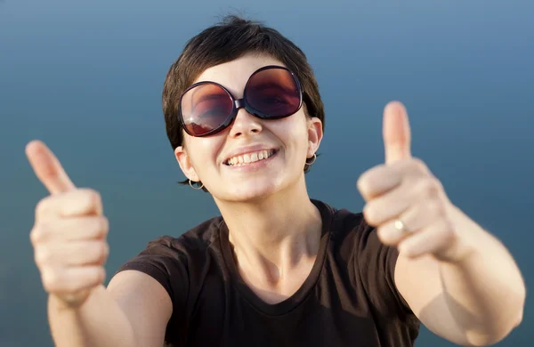 Young brunette girl with big funny sunglasses making thumbs up gesture — Stock Photo, Image