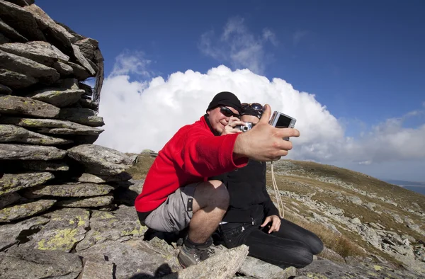 Hiker couple taking pictures up in the mountains — Stock Photo, Image