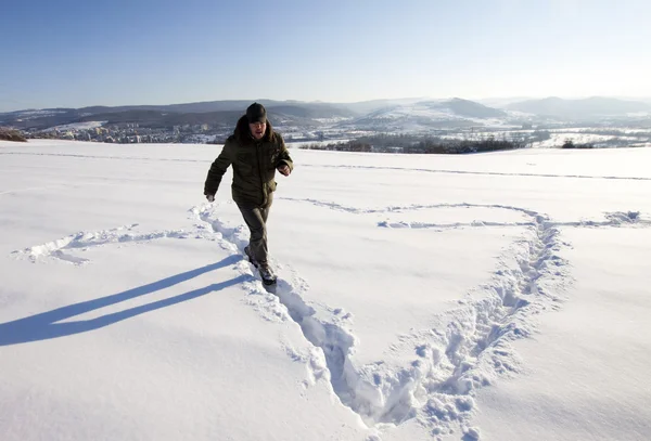 Uomo che fa grande segno di neve nella neve — Foto Stock