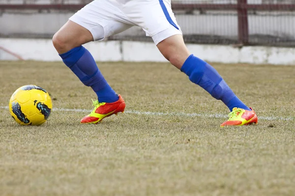 Giocatore di calcio calci il pallone — Foto Stock