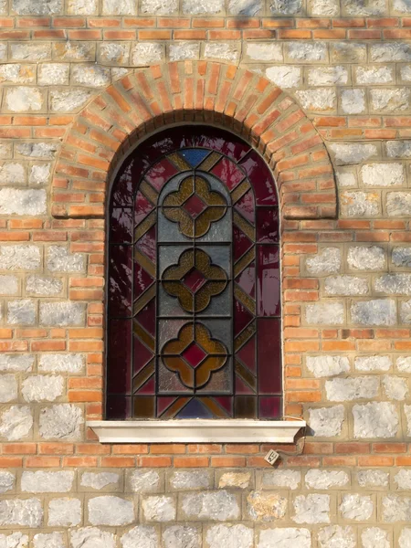 Stained glass window in a stone wall — Stock Photo, Image