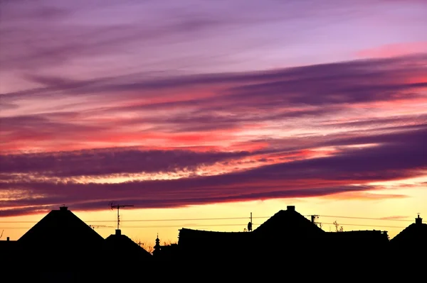 Sunset with clouds above houses. — Stock Photo, Image