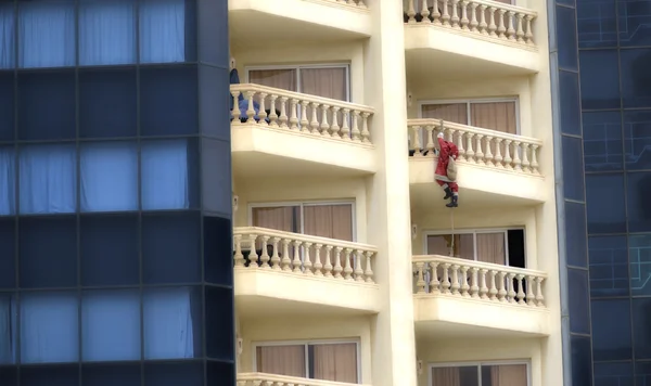 Santa Claus climbing a building in Chritmas day — Stock Photo, Image