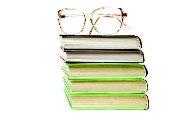 Изолированная стопка книг с очками — стоковое фото
