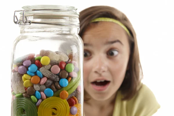 Girl looking at sweet jar — Stock Photo, Image