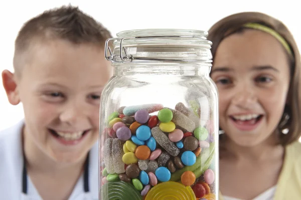 Girl & boy looking at sweet jar — Stock Photo, Image