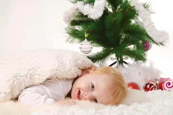 Santa boy lies near the Christmas tree — Stock Photo, Image
