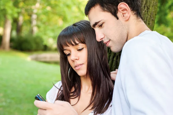 Mladý pár a mobilní telefon — Stock fotografie