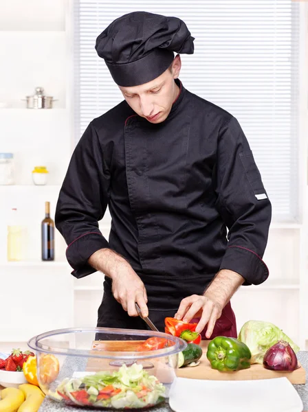 Chef corte de pimentas na cozinha — Fotografia de Stock