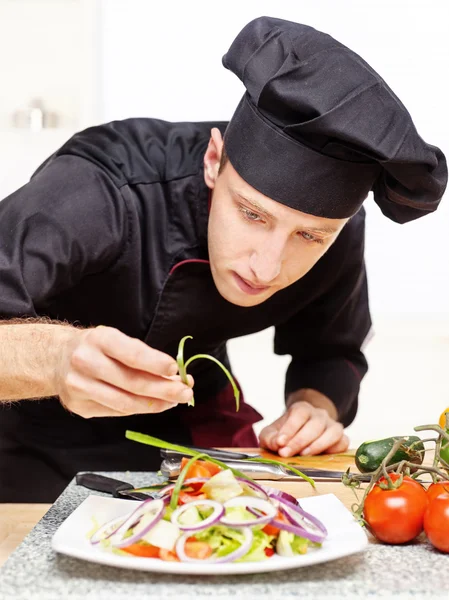 Chef décorant délicieuse assiette de salade Images De Stock Libres De Droits