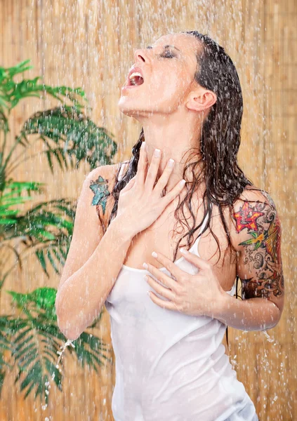 Vrouw met tatoeages onder douche — Stockfoto