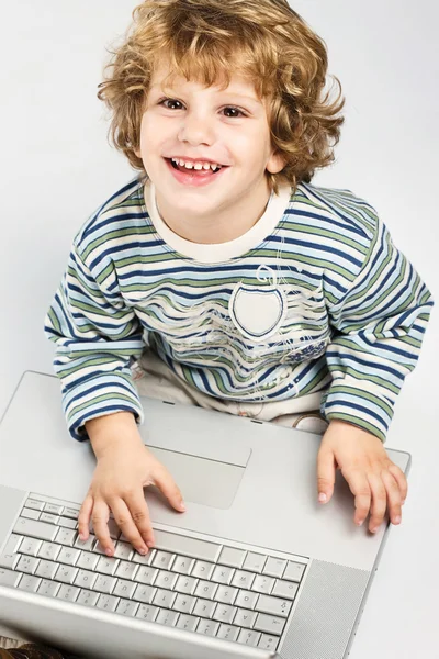 Jongen bedrijf laptop en glimlachen — Stockfoto