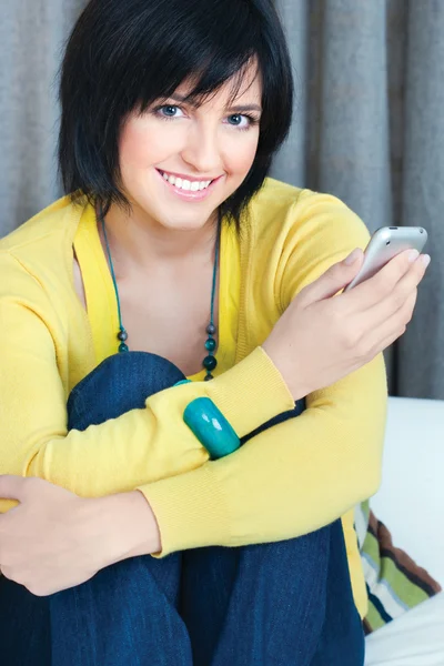 Chica usando el teléfono móvil en casa — Foto de Stock