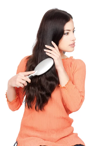 Mulher bonita penteando seu longo cabelo preto — Fotografia de Stock