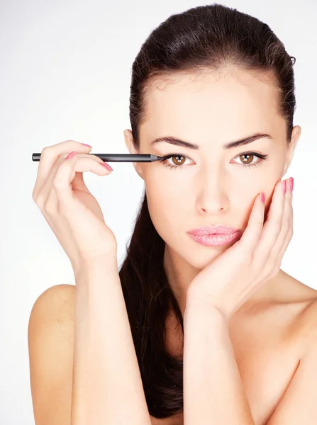 Vrouw cosmetische potlood toe te passen op oog — Stockfoto