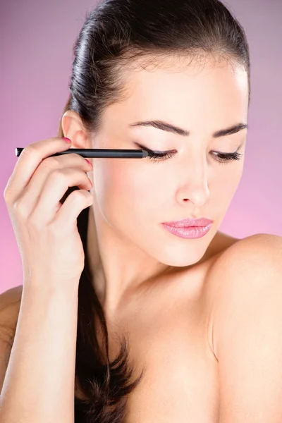 Vrouw cosmetische potlood toe te passen op oog — Stockfoto