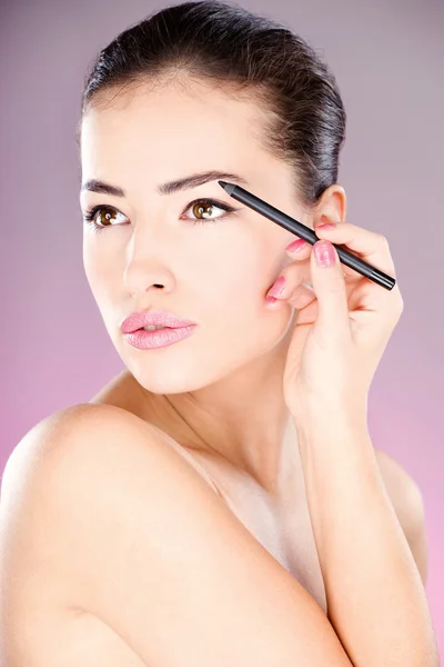 Mujer aplicando lápiz cosmético en el ojo —  Fotos de Stock