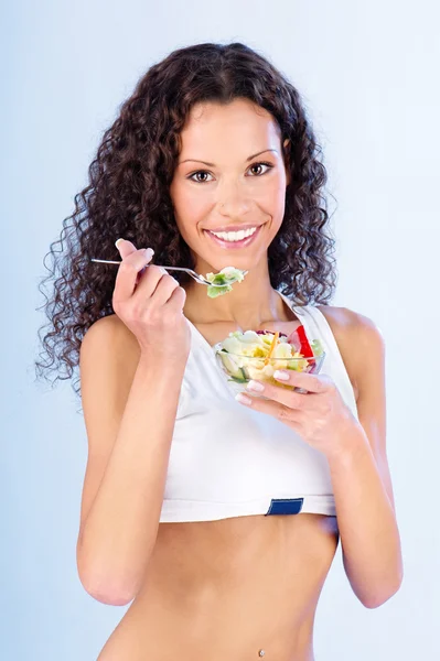 У женщины есть салат на вилке — стоковое фото