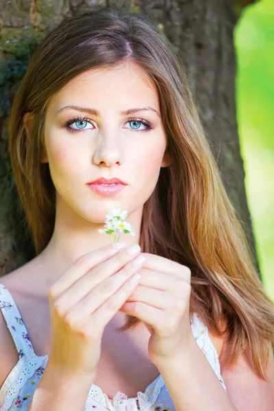 Woman in park holding spring flowers — Stock Photo, Image