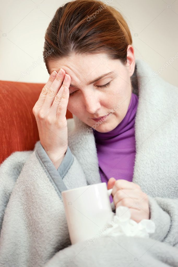 Sick woman covered with blanket at home