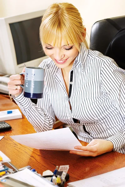 Mulher de negócios loira verificando os papéis no escritório — Fotografia de Stock